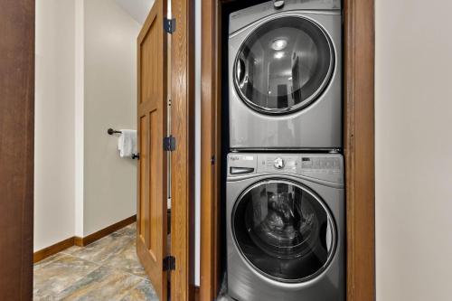 a washing machine and a washer and dryer in a room at Settler's Crossing #56 ski-in ski-out condo with private hot tub in Sun Peaks