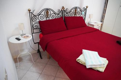 a bedroom with a red bed with two towels on it at Vatican R(h)ome in Rome