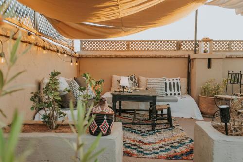 an outdoor patio with a table and a couch at Riad Djebel in Marrakech