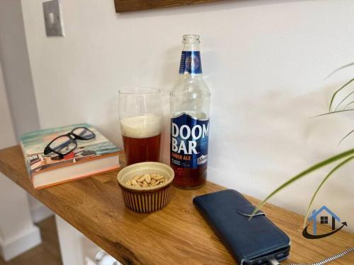 a bottle of beer and a bowl of nuts and a drink at Petham Cottage Stanwick 2 bed sleeps 6 in Stanwick