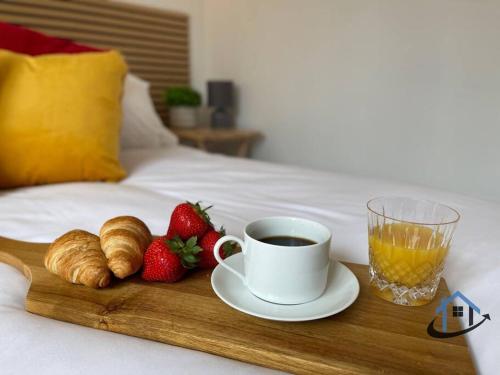 a tray with a cup of coffee and strawberries on a bed at Petham Cottage Stanwick 2 bed sleeps 6 in Stanwick