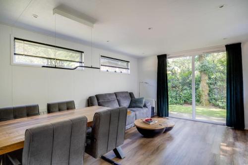 a living room with a table and a couch at Modern huisje op de Veluwe in Epe