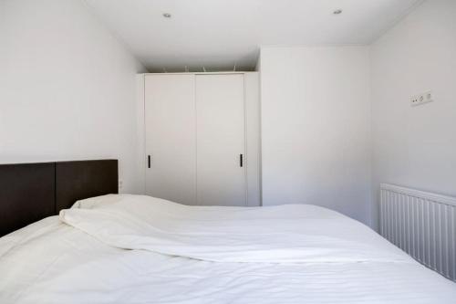 a white bed in a room with a window at Modern huisje op de Veluwe in Epe