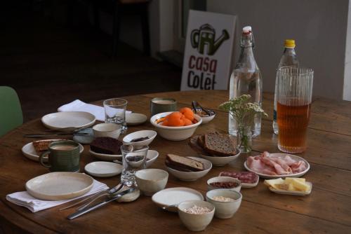 a wooden table topped with plates and bowls of food at StarsBox a Casa Colēt in Frabosa Sottana