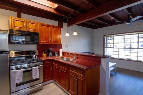 a kitchen with wooden cabinets and stainless steel appliances at Edgewater Beach Inn in Santa Cruz