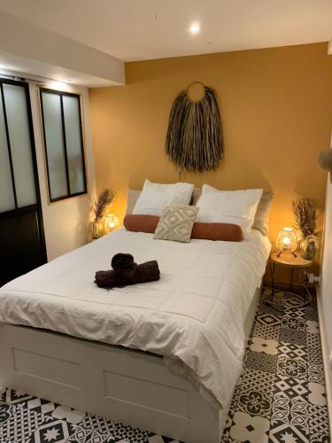 une chambre avec un grand lit avec des draps blancs dans l'établissement Les Logis de Candide, à La Teste-de-Buch