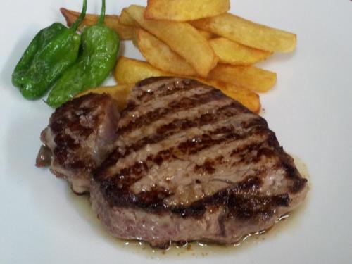 a steak and french fries on a white plate at La Mira de Gredos in Hoyos del Espino