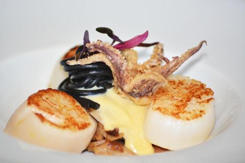 a plate of food with seafood on a white plate at La Mira de Gredos in Hoyos del Espino