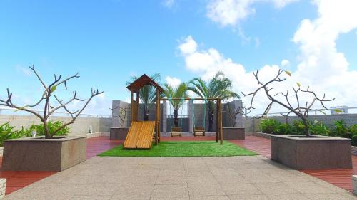 a park with a playground with a slide and trees at Edifício JTR Apartamentos Beira Mar in Maceió