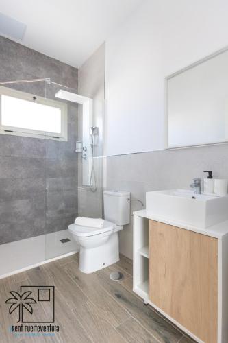 a bathroom with a toilet and a sink and a shower at Lola Loft Lajares iRent Fuerteventura in La Oliva