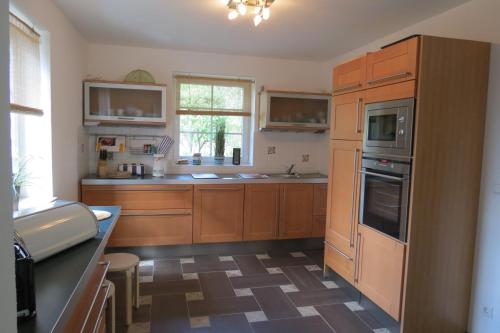 a kitchen with wooden cabinets and stainless steel appliances at Seebär in Groß Schwansee
