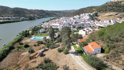 an aerial view of a village on a hill next to a river at Casas Rurales Los Molinos in Sanlúcar de Guadiana