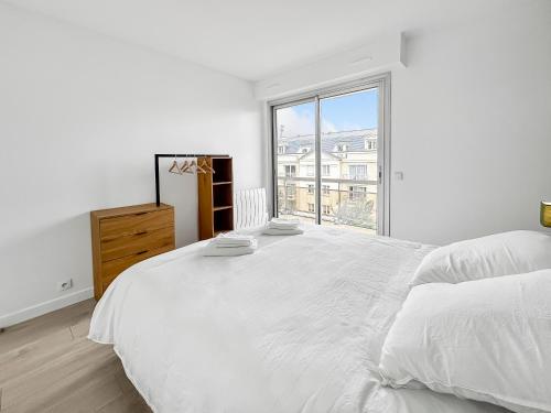 une chambre blanche avec un grand lit et une fenêtre dans l'établissement Détente Près de la Capitale à Antony, à Antony