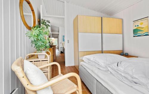 a small bedroom with a bed and a chair at 2 Bedroom Cozy Home In Nykøbing Sj in Nykøbing Sjælland