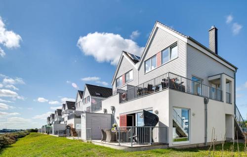 a large white house with balconies on a hill at Am Yachthafen in Olpenitz