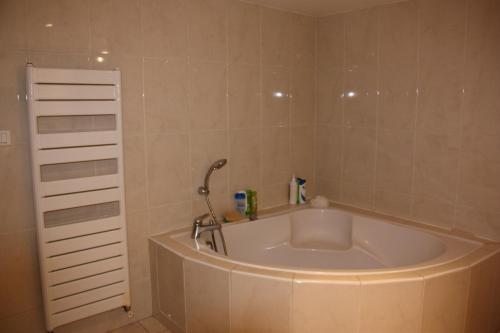 une baignoire avec un robinet dans une salle de bain dans l'établissement PETITE MAISON D'HÔTE et SON PATIO au PIED DE NOTRE-DAME, à Marseille