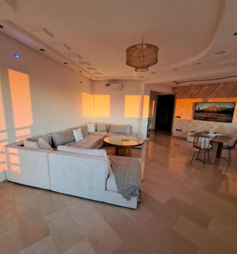 a living room with a white couch and a table at Tanger, Vue Mer Panoramique in Noûnouech