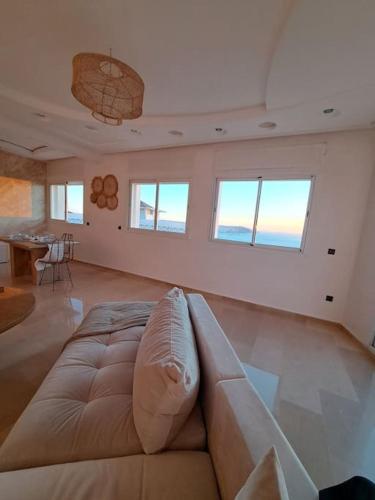 a large living room with a couch and a table at Tanger, Vue Mer Panoramique in Noûnouech