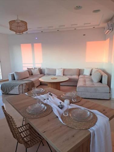 a living room with a table and a couch at Tanger, Vue Mer Panoramique in Noûnouech