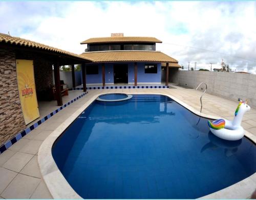 ein Schwimmbad mit einem Schwan und einem Gebäude in der Unterkunft Casa de praia barra Serinhaém,Carneiros,ilha santo aleixo in Sirinhaém