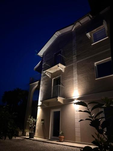 a white building with a balcony at night at B&B Villa Antilia in Busca