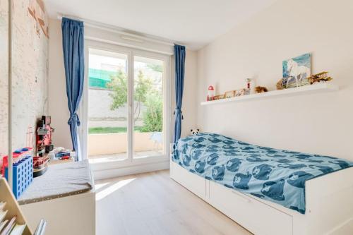 une chambre avec un lit et une fenêtre dans l'établissement Bel Appart Lumineux avec Jardin, 3 chambres pour 6 personnes, à Marseille