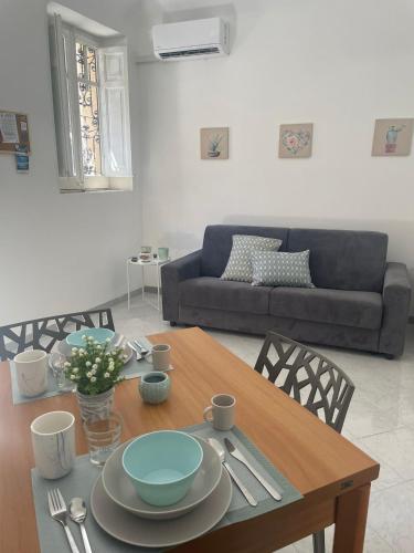 a living room with a table and a couch at LA CASTELLANA Apartments in Carini