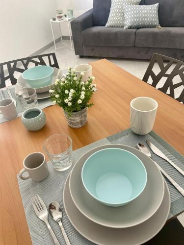 a dining room table with plates and utensils on it at LA CASTELLANA Apartments in Carini