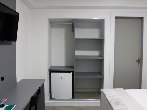 a room with a closet with a refrigerator in it at Hotel Sagres Praia in Balneário Camboriú