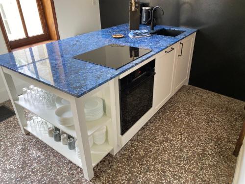 - une cuisine avec un comptoir bleu et un évier dans l'établissement Villa Léontine Wimereux, à Wimereux