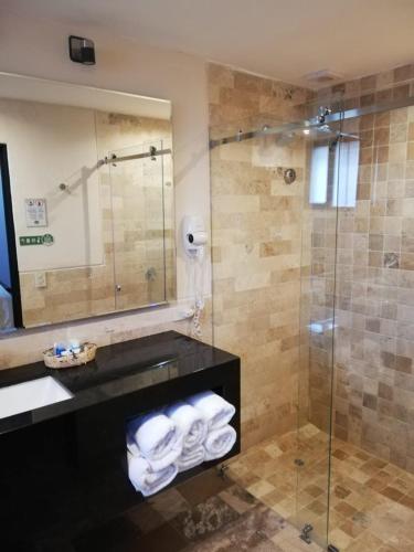 a bathroom with a shower and a sink with towels at Termas de Papallacta in Papallacta