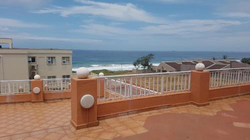 a balcony with a view of the ocean at Golden Dawn Chalets in La Mercy
