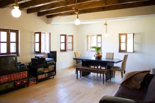a living room with a table and a tv at Telhados de Xisto in Lousã