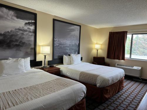 a hotel room with two beds and a window at Super 8 by Wyndham Mason City in Mason City