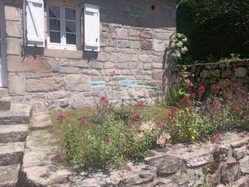 a stone house with flowers in front of it at Gîte de France Gîte des veyssières 3 épis - Gîte de France 4 personnes MAE-9654 in Bru