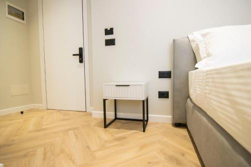 a bedroom with a bed and a side table at Mina Luxury Rooms in Tirana