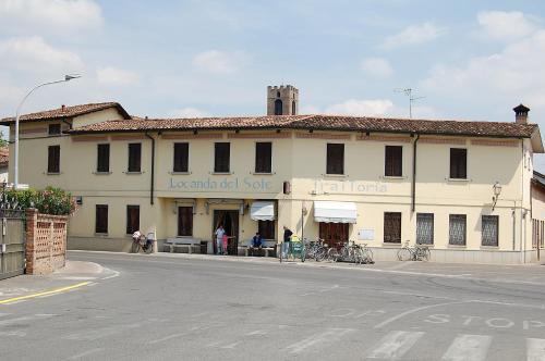 a large white building on the side of a street at Locanda Del Sole in Mozzanica
