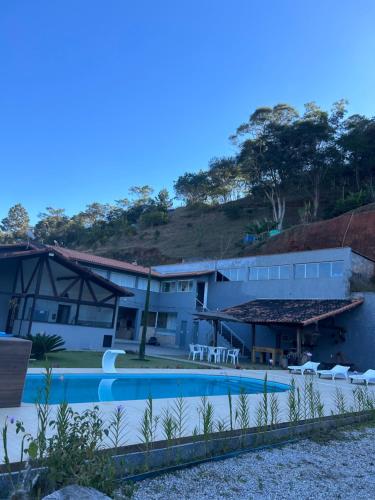 a resort with a swimming pool and a building at Sitio Real Cascata in Teresópolis