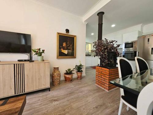 a living room with a flat screen tv and a table at House of Belverde with Pool in Amora