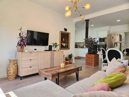 a living room with a couch and a table at House of Belverde with Pool in Amora