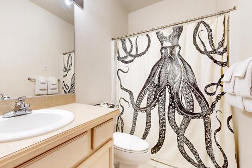 a bathroom with a sink toilet and a shower curtain at Beach Stroll Haven in Gearhart