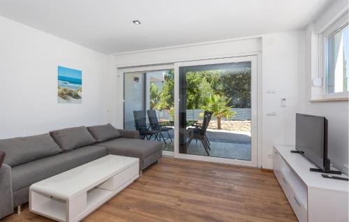 Una sala de estar con un sofá y un televisor. en 3 Bedroom Amazing Apartment In Malinska, en Malinska