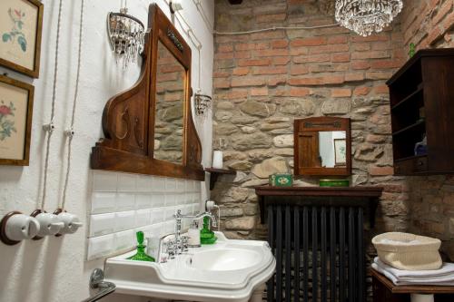 a bathroom with a sink and a stone wall at La Buca in Castello di Serravalle