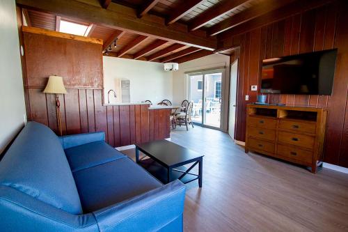a living room with a blue couch and a kitchen at Edgewater Beach Inn in Santa Cruz