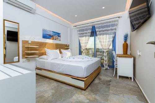 Un dormitorio con una cama y una ventana grande. en Cindy Luxury Villas Crete BLUE, en Stavros