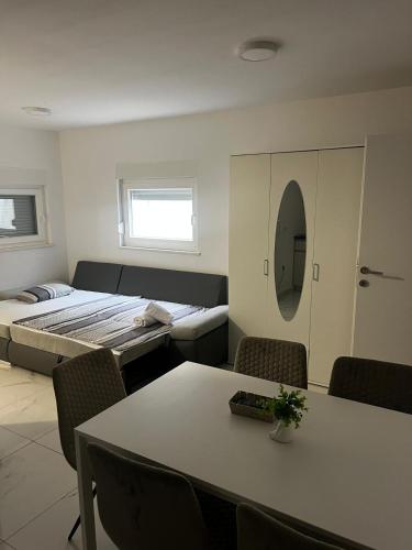 a room with two beds and a table and chairs at Apartments Pool Villa Maria, Novalja in Novalja