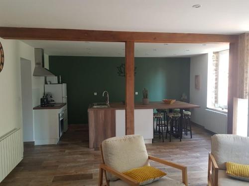 une cuisine et un salon avec une table et des chaises dans l'établissement Gite Le Nymphéa, La Cambre, à Saint-Aubert-sur-Orne
