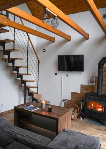 a living room with a staircase and a fireplace at Domki pod Bukowym lasem in Wańkowa