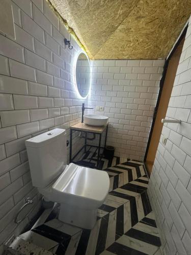 a bathroom with a white toilet and a sink at Citrica in T'khilnari