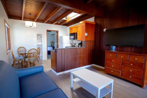 a living room with a blue couch and a tv at Edgewater Beach Inn in Santa Cruz